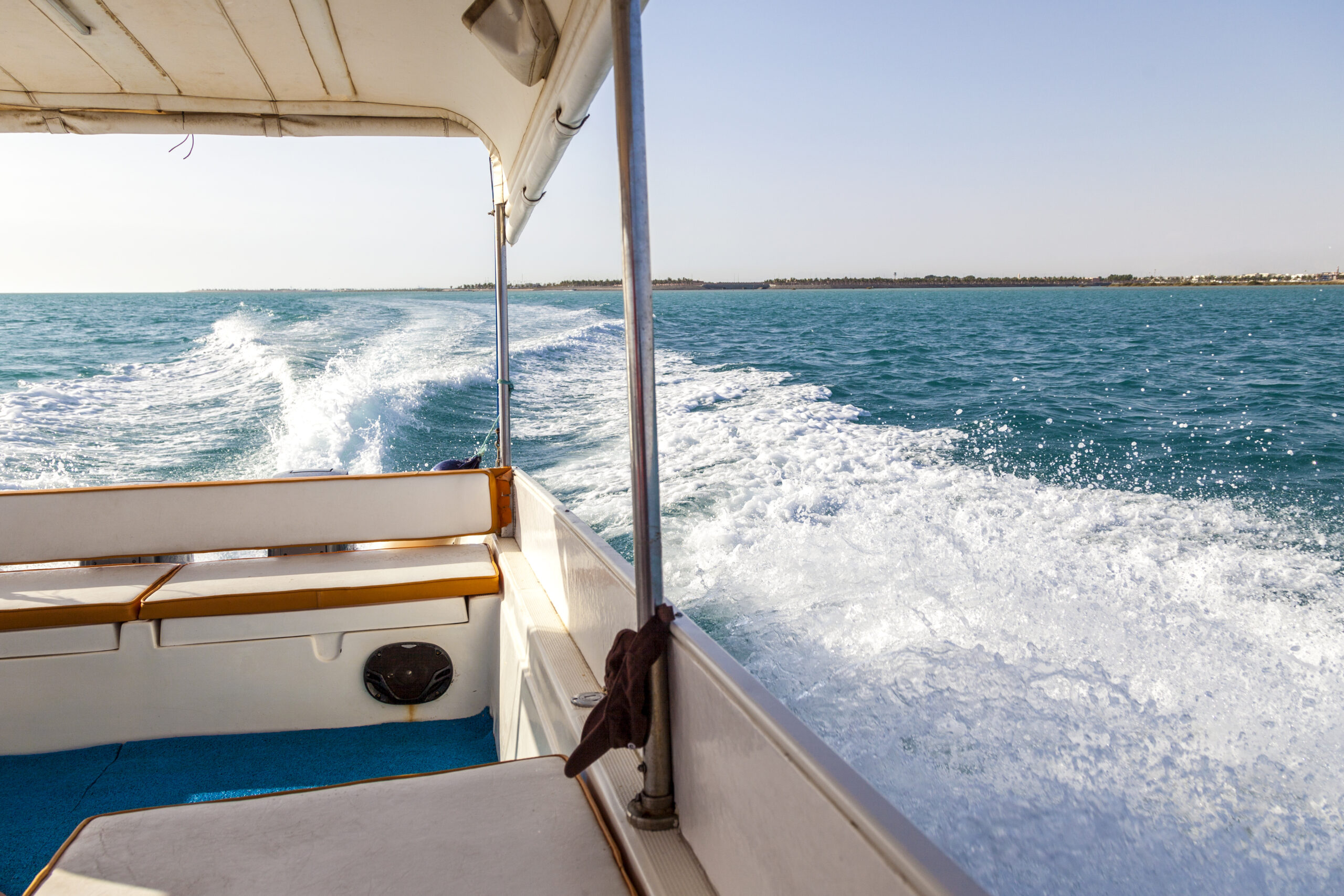 Boat leaving wake on blue water