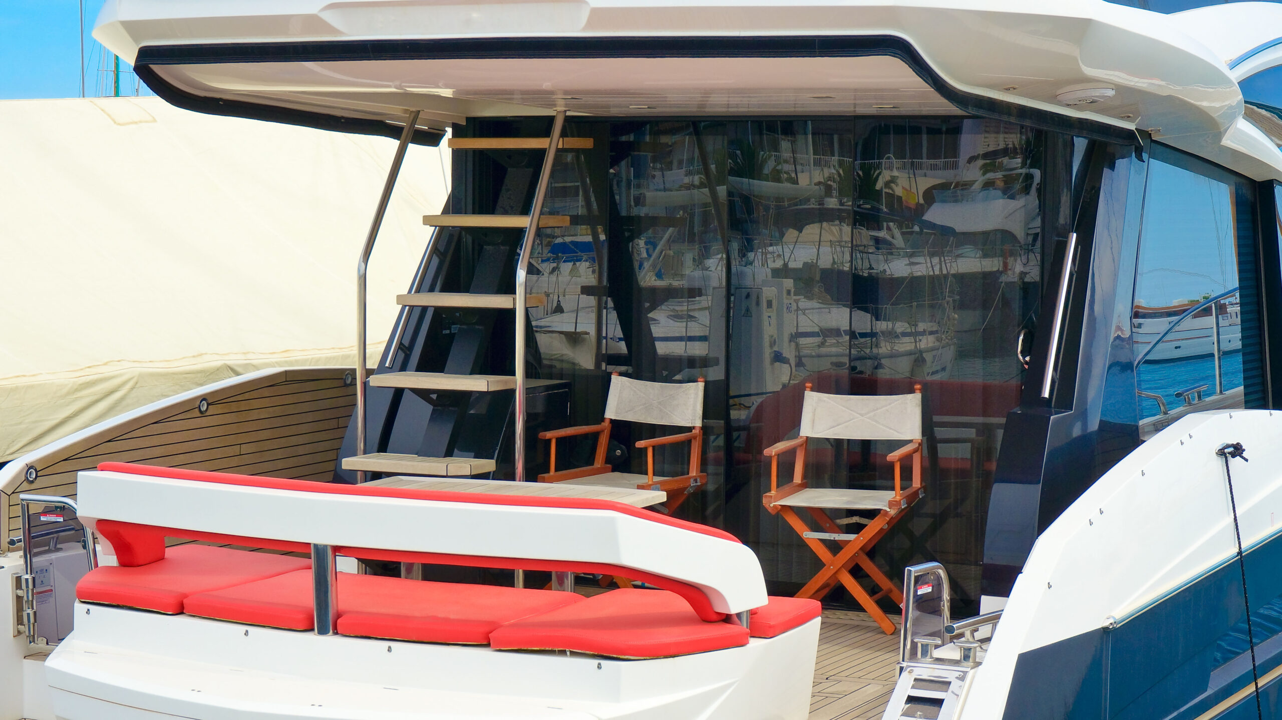 Yacht deck featuring wooden chairs and ladder