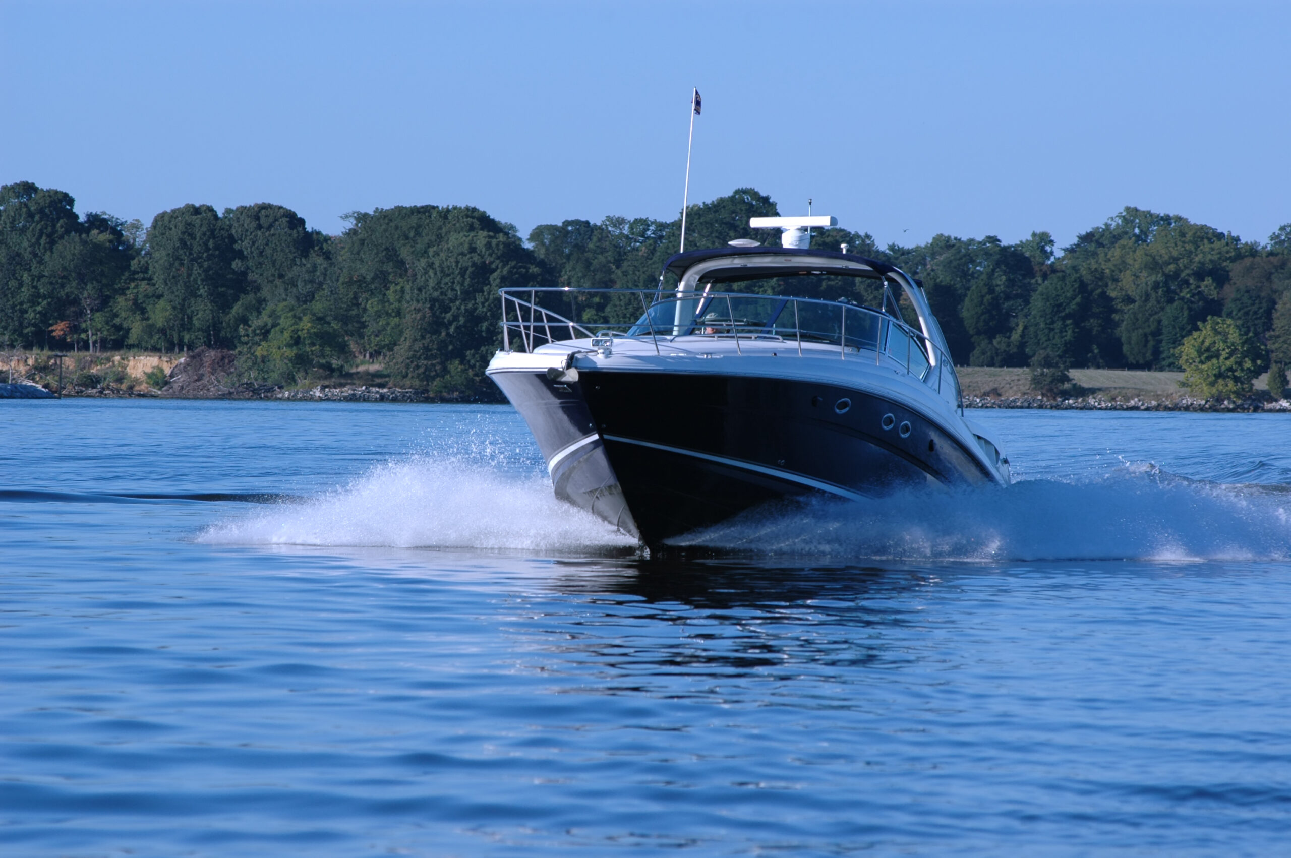 Boat creating waves on blue lake