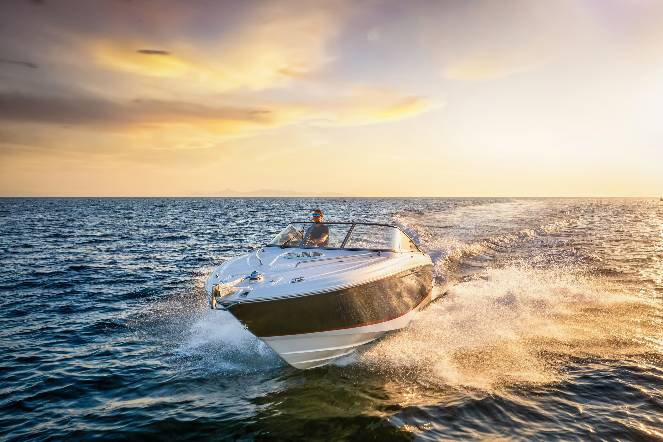 White speedboat creating waves in the ocean